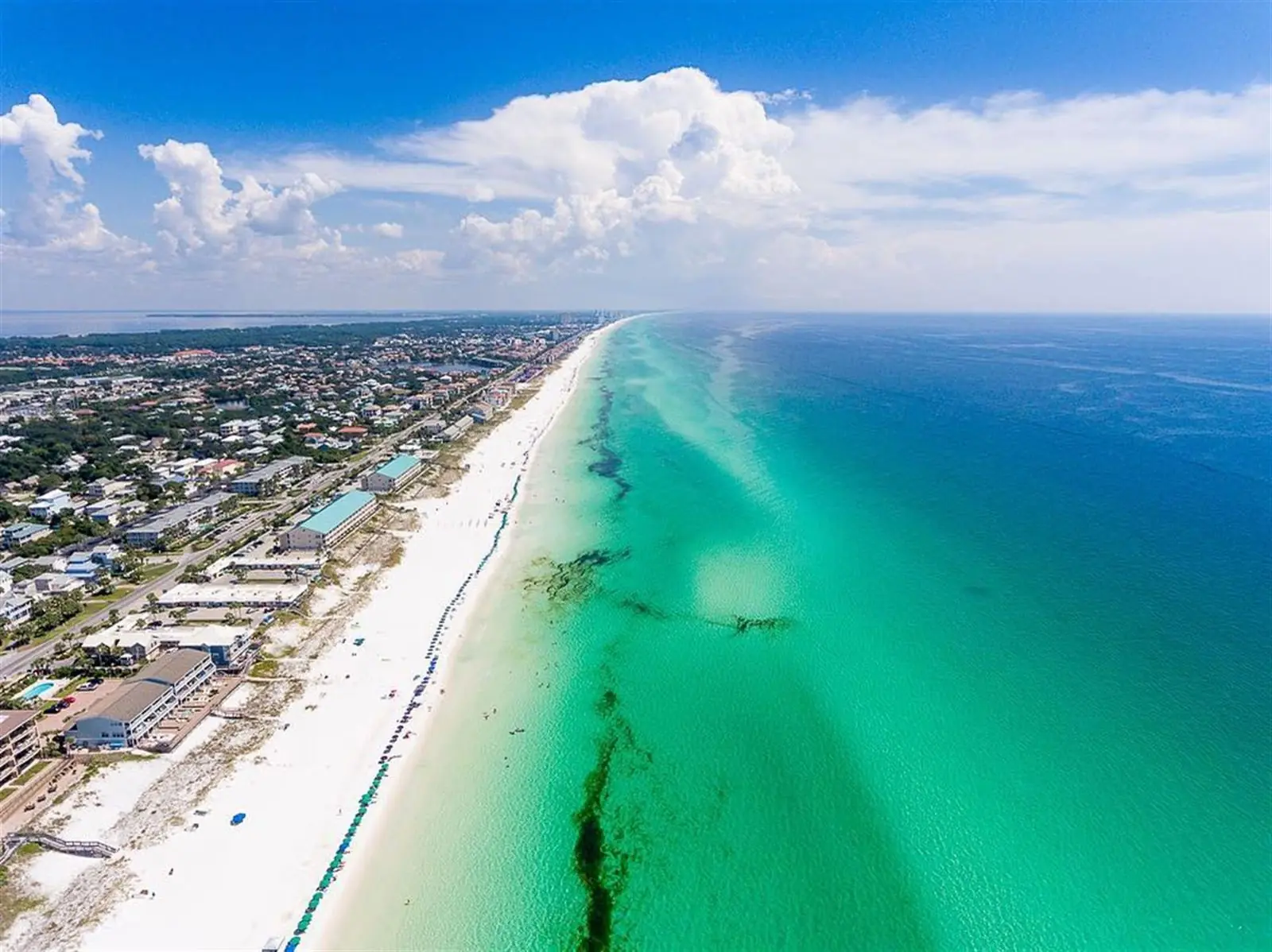 Aerial view of the white sand and emerald water of Florida's Emerald Coast